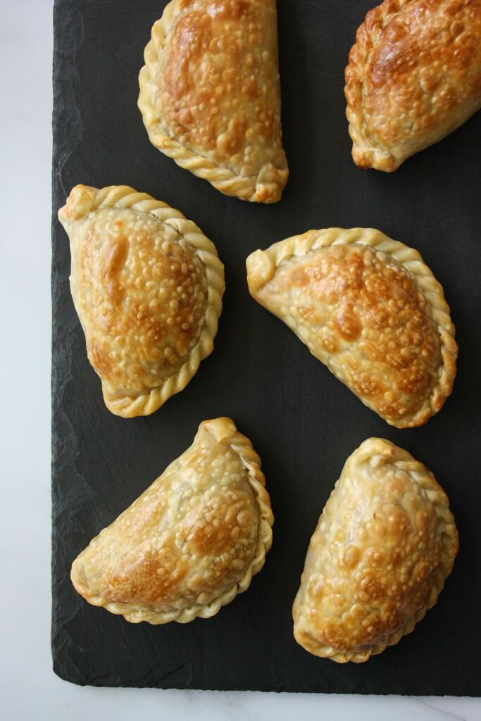 six beef empanadas from above on a black chalk tray